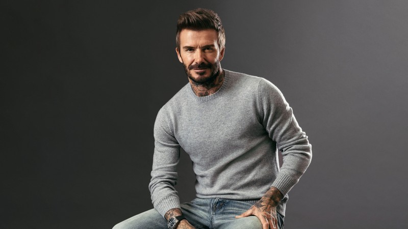 Мужчина с бородой сидит на табурете с руками на бедрах (дэвид бекхэм, david beckham, портрет, english football player, 5k)