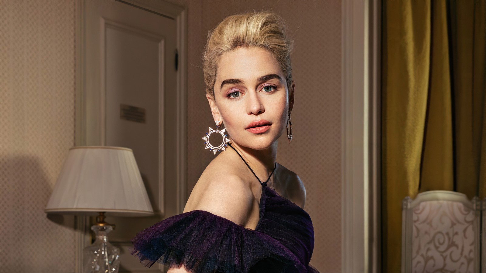 Une femme arabe en robe violette posant dans une pièce (emilia clarke, anglais, actrice, célébrité, femmes)