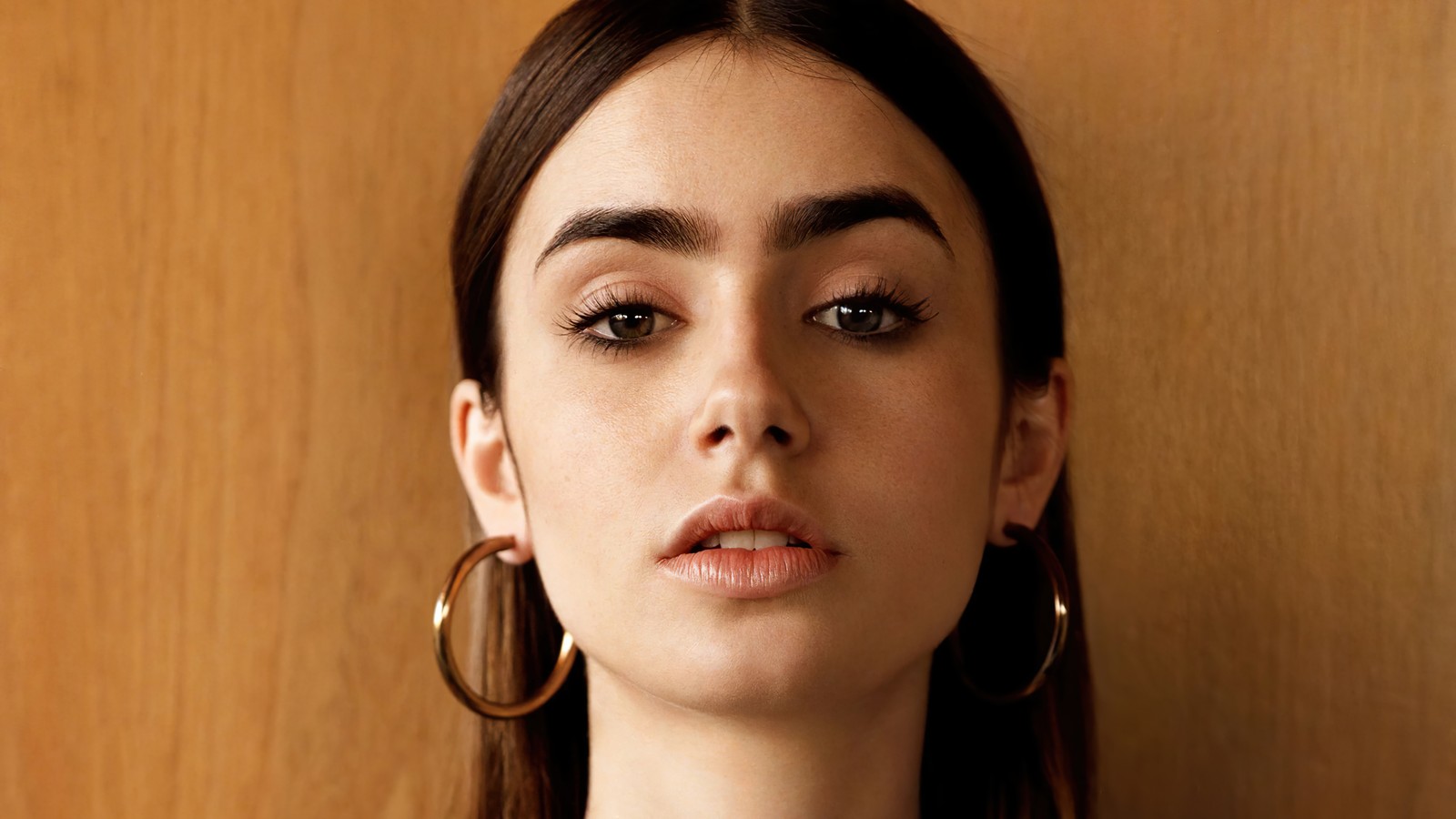 Femme arafed avec de grandes boucles d'oreilles et un haut noir (lily collins, américain, britannique, actrice, célébrité)