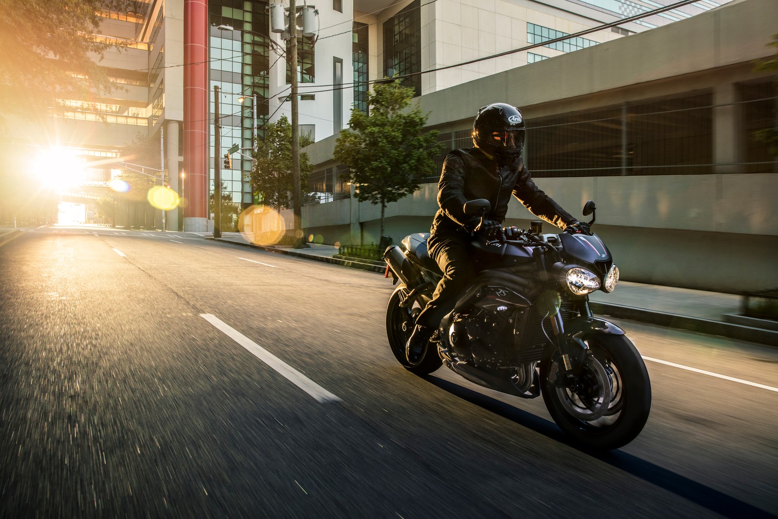 Araffe riding a motorcycle on a city street at sunset (triumph motorcycles ltd, motorcycle, motorcycling, car, cruiser)