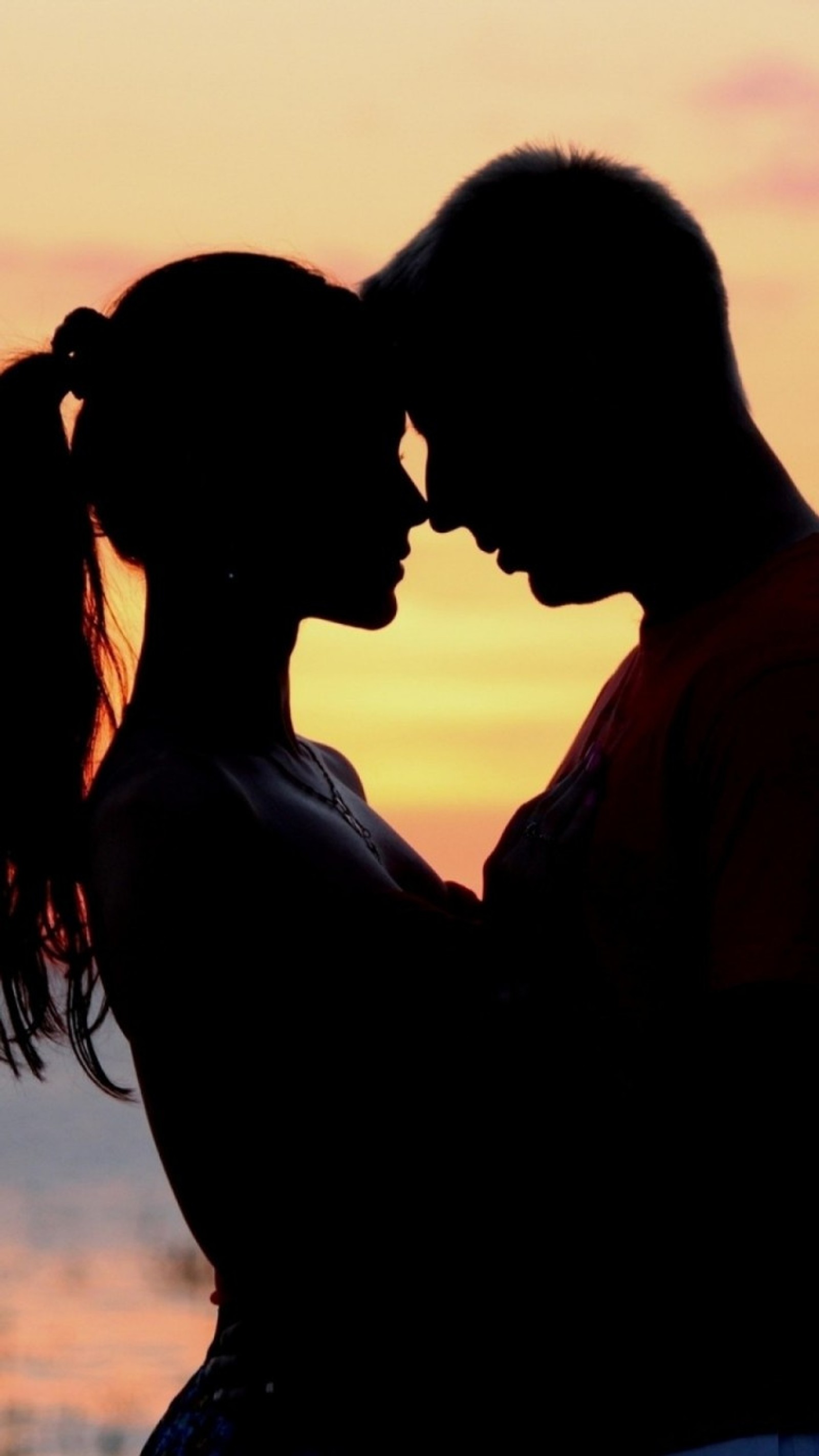 Silhouette d'un homme et d'une femme s'embrassant au coucher du soleil sur la plage (a couple, beau, everafter, foi, heureux)