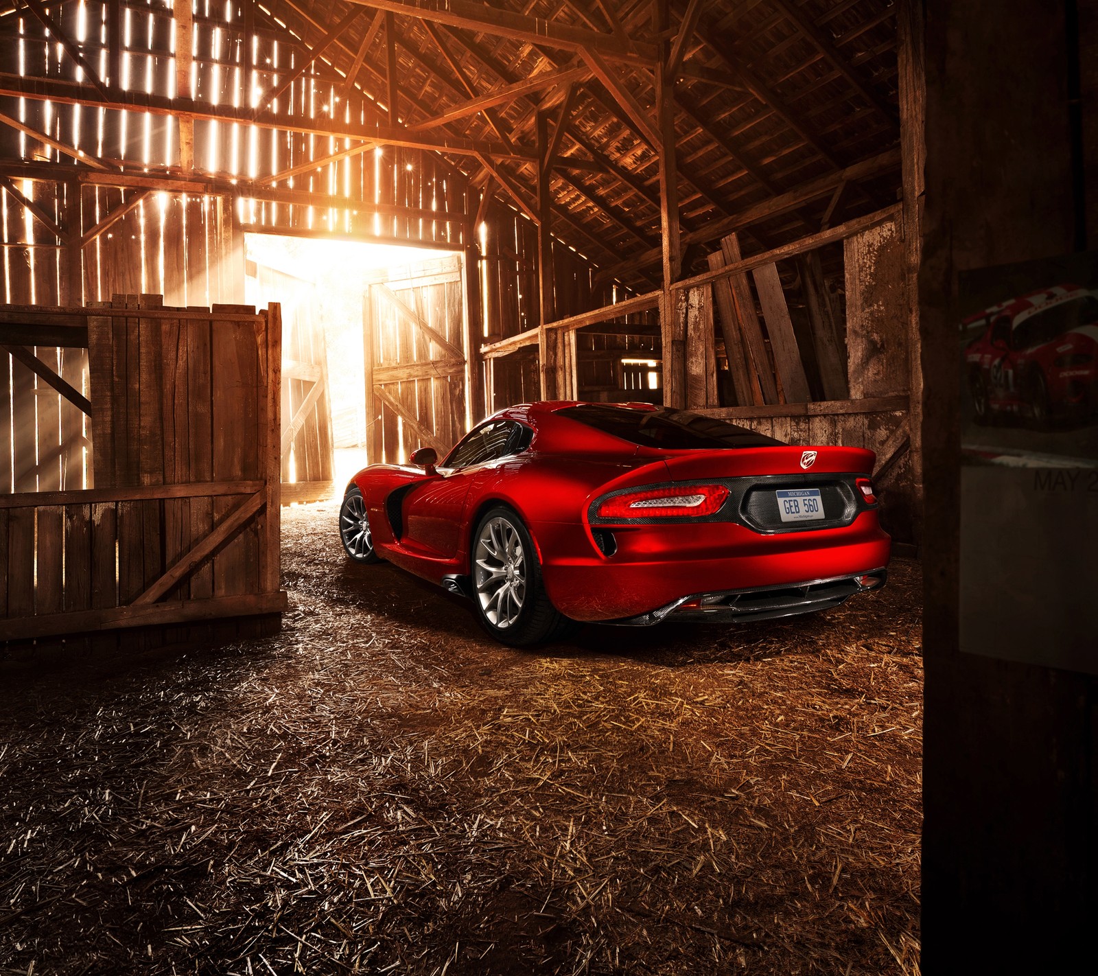 A close up of a red sports car parked in a barn (auto, car, dodge, viper)