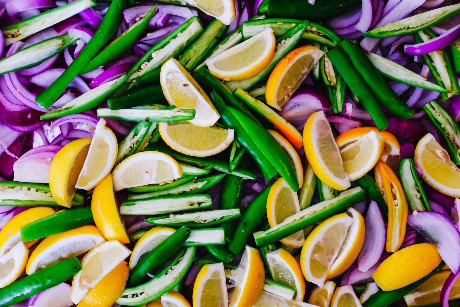 Un primer plano de un montón de verduras con limones y cebollas (verdura, especias, comida, cocina, ingrediente)