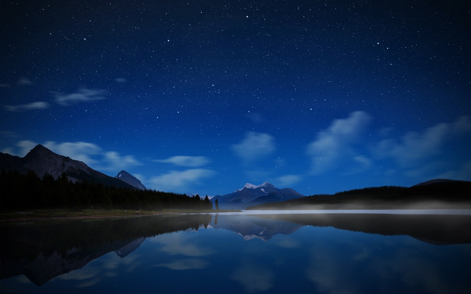 Un lago con una montaña al fondo y un cielo lleno de estrellas (noche, naturaleza, reflexión, tierras altas, agua)