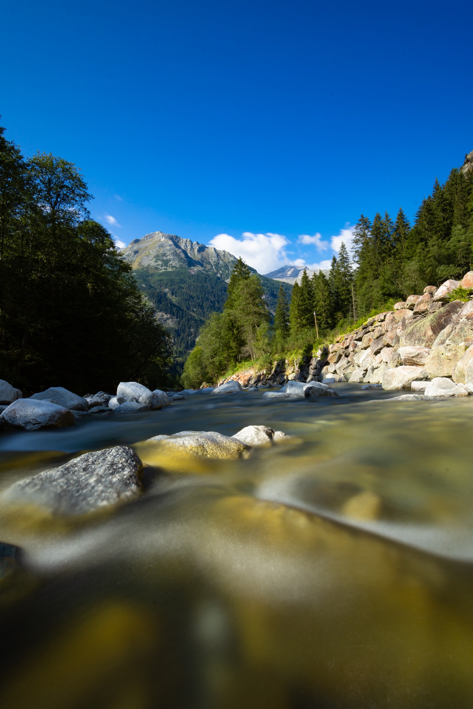 Há um rio com pedras e água nele (natureza, água, nuvem, recursos hídricos, montanha)