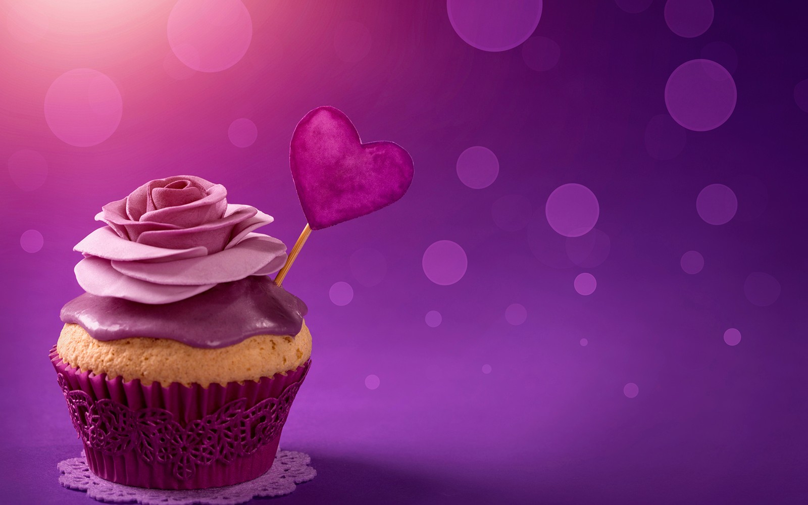 Purple cupcake with a heart shaped stick on top of it (cupcake, cake, purple, sweetness, icing)