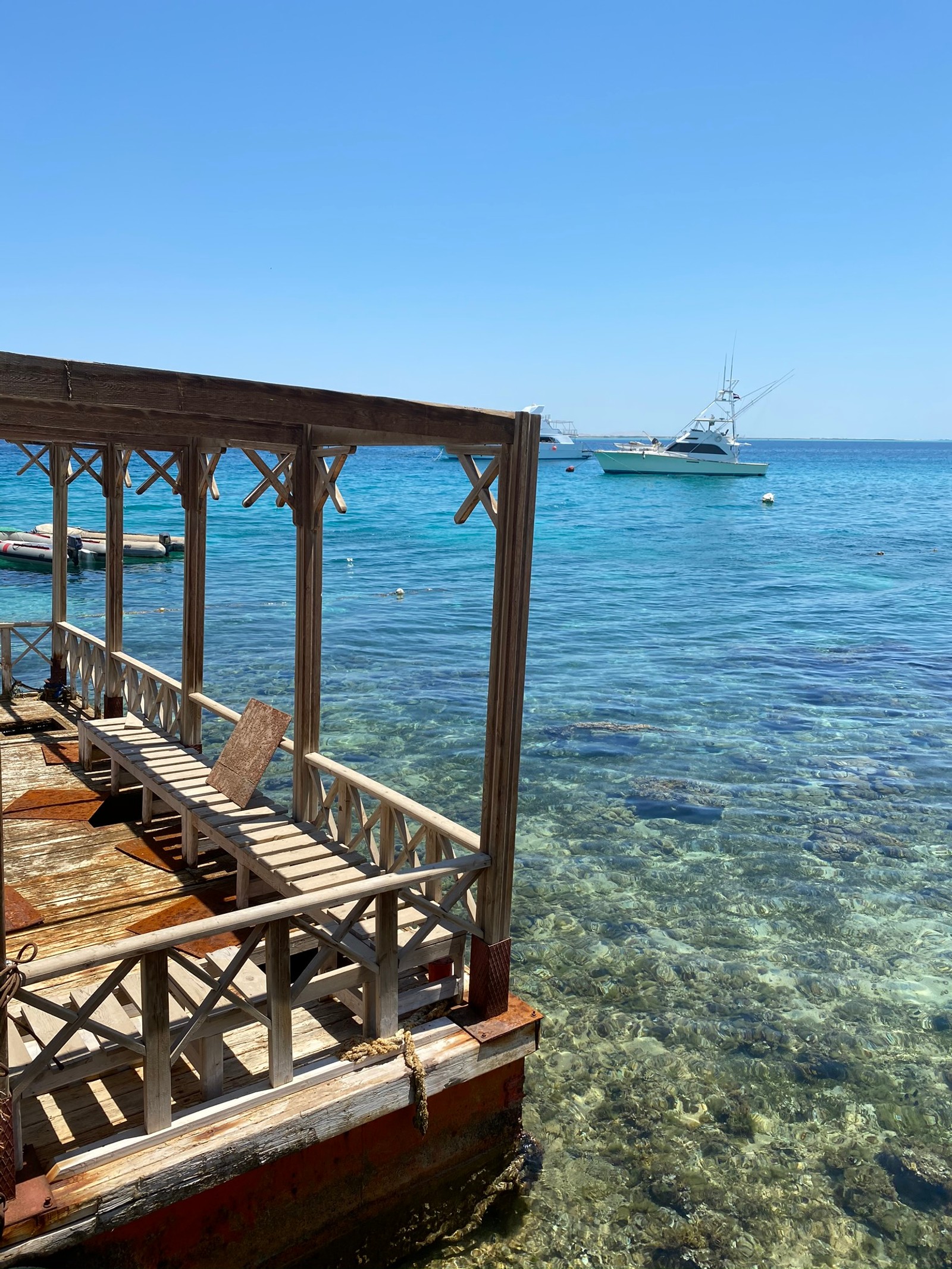 Há um barco na água perto de um cais (mar, barco, água, horizonte, oceano)