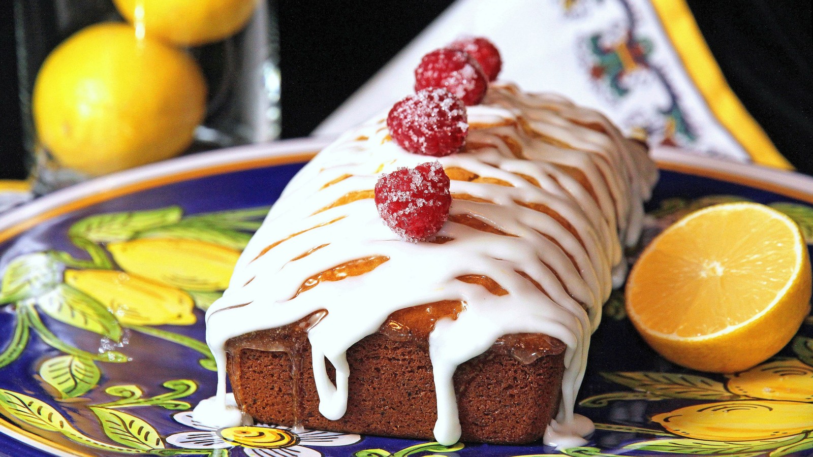 Il y a un gâteau avec du glaçage et des framboises sur une assiette (gâteau, tarte, glaçage, gâteau danniversaire, dessert)