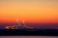 Sérénité crépusculaire : pont illuminé contre un horizon du crépuscule