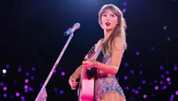 Taylor Swift se apresentando na The Eras Tour com guitarra e presença de palco cativante