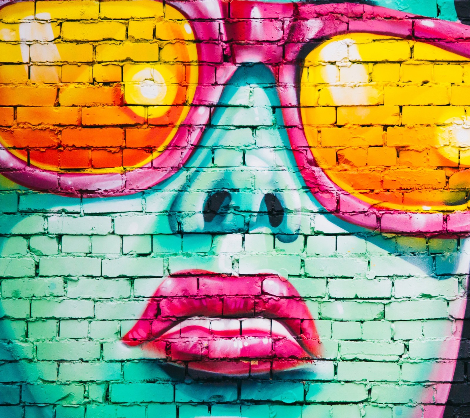 Graffiti art of a woman with sunglasses on a brick wall (art, color, face, graffiti)