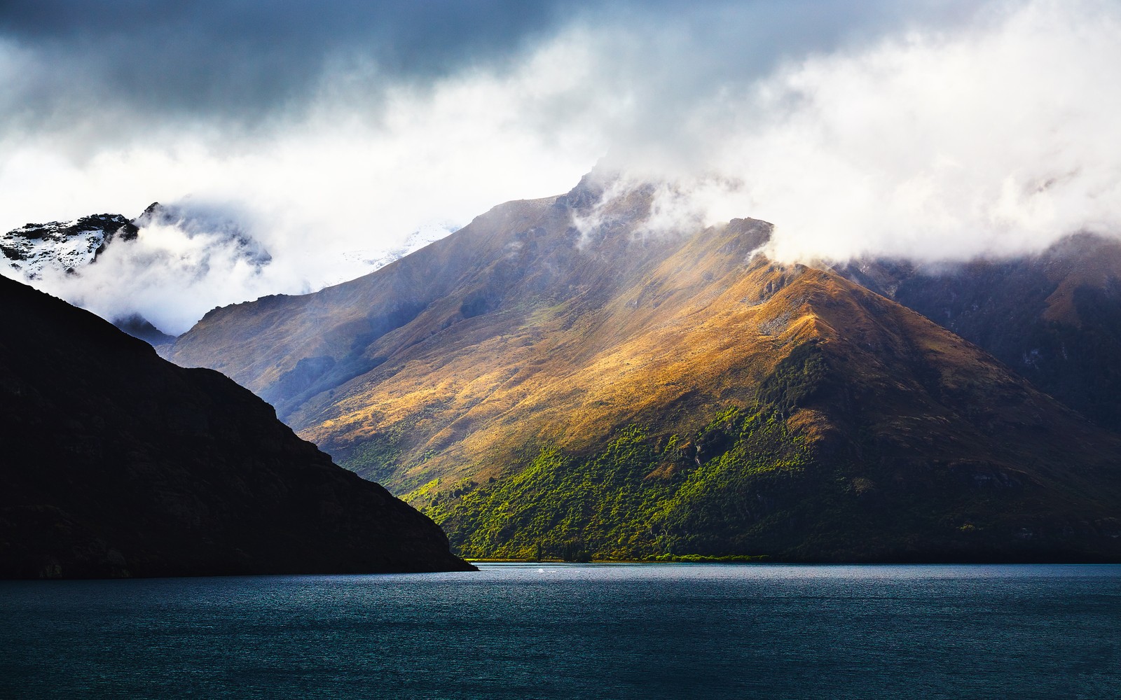 Montanhas com um lago e um barco em primeiro plano (terra, nuvem, água, montanha, paisagem natural)