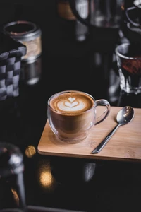 Latte artisticamente elaborado com design de coração em uma bandeja de madeira