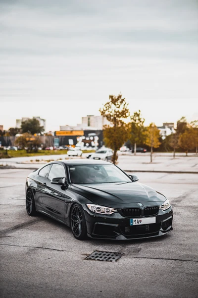 Berline BMW 4 Series noire avec des jantes blanches dans un cadre urbain