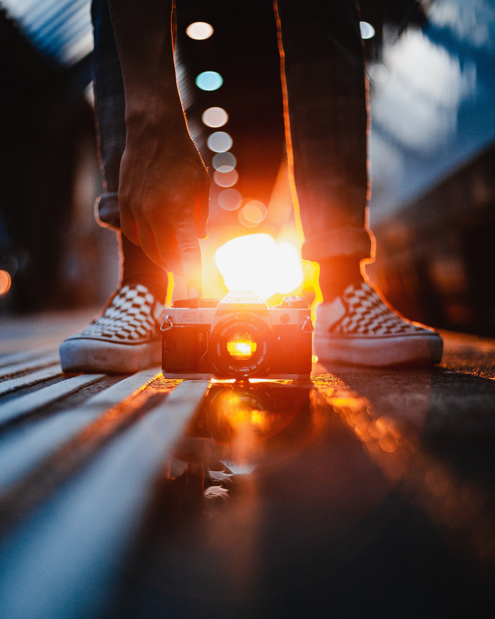 Someone standing on a skateboard with a light on it (camera, light, heat, lighting, flame)