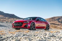 2021 Audi RS 7 Sportback in auffälligem Rot vor einer rauen Landschaft.