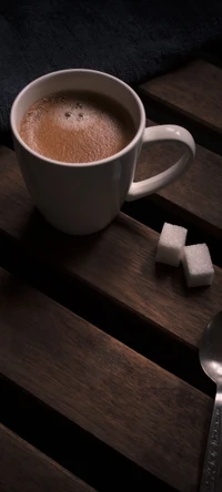 Espresso cubano en una taza blanca con terrones de azúcar sobre una mesa de madera