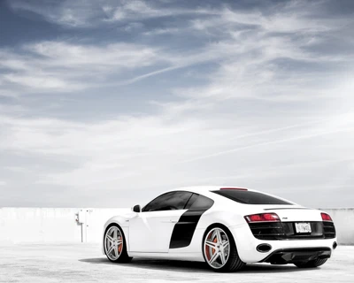 Elegante Audi R8 supercar branco com rodas personalizadas contra um céu dramático.