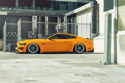 Benutzerdefinierter orangefarbener Ford Mustang mit Tuning in städtischer Umgebung