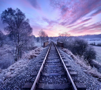 Mit Frost bedeckte Bahngleise unter einem lebhaften Sonnenaufgang in Belgrad.