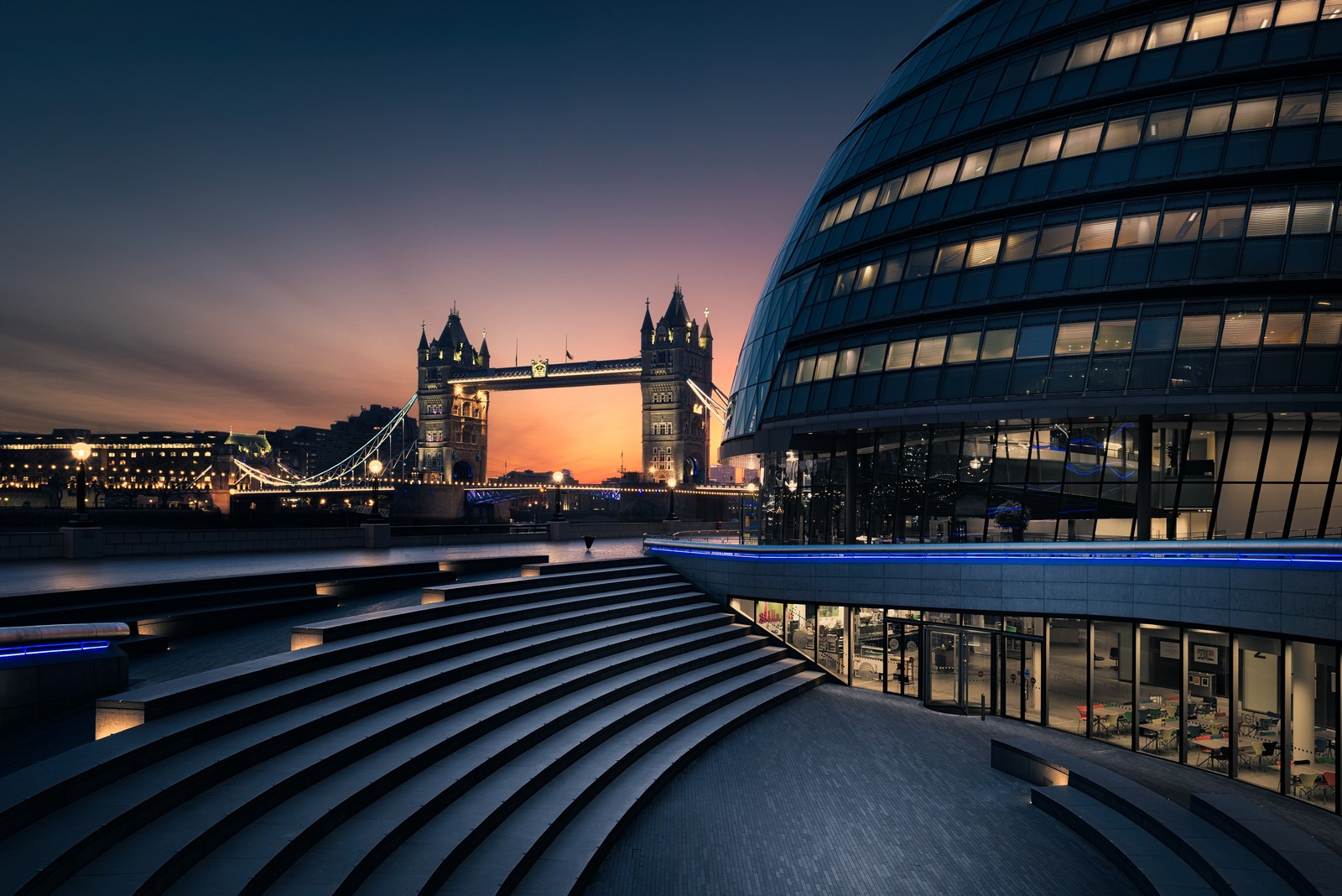 Una vista de un edificio con un puente de torre al fondo (gran bretaña, inglaterra, england, londres, london)