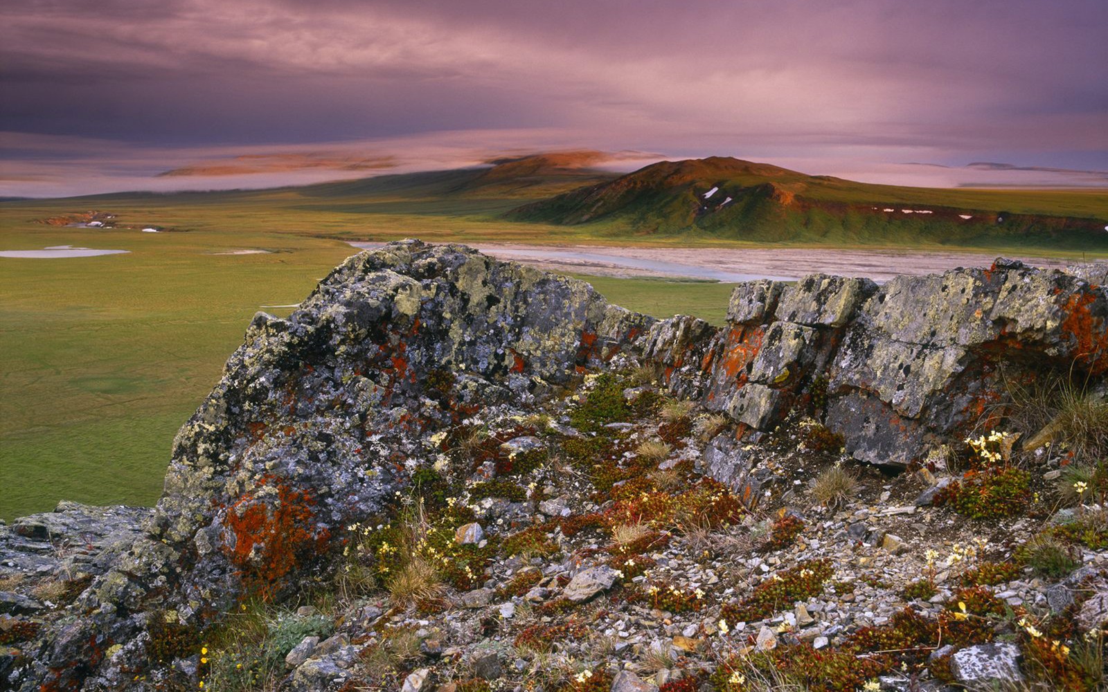 Eine luftaufnahme eines felsigen vorkommens mit einem see in der ferne. (natur, fels, tundra, gefallen, landschaft)