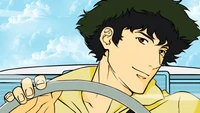 Spike Spiegel in einem Cabrio vor einem hellen Himmel.