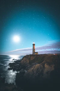 Faro de luz bajo un cielo estrellado