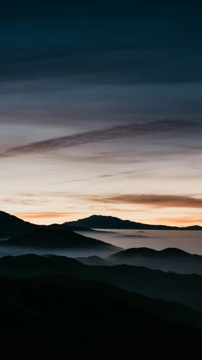 Serene Highland Sunset: A Natural Landscape of Mountains and Clouds