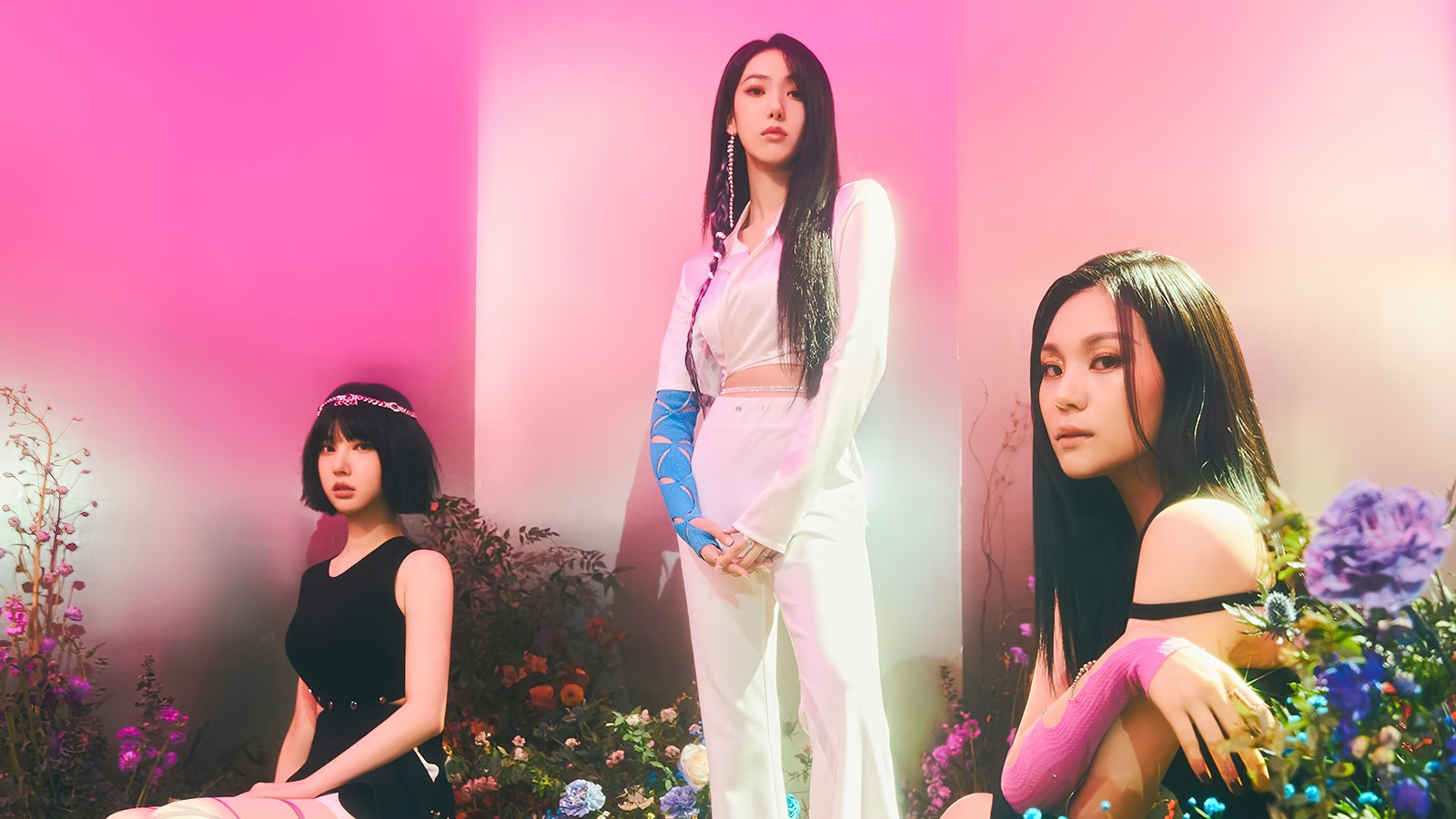 Deux femmes assises sur un lit de fleurs devant un mur rose (viviz, 비비지, kpop, k pop, groupe de filles coréen)