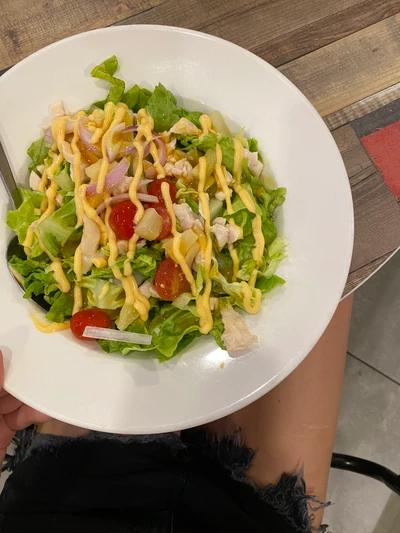 Ensalada fresca con hojas verdes, tomates cherry y aderezo cremoso