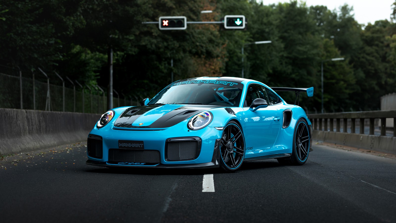 A close up of a blue sports car driving down a road (manhart tr 700 ii, porsche 911 gt2 rs, 5k, cars, 4k wallpaper)