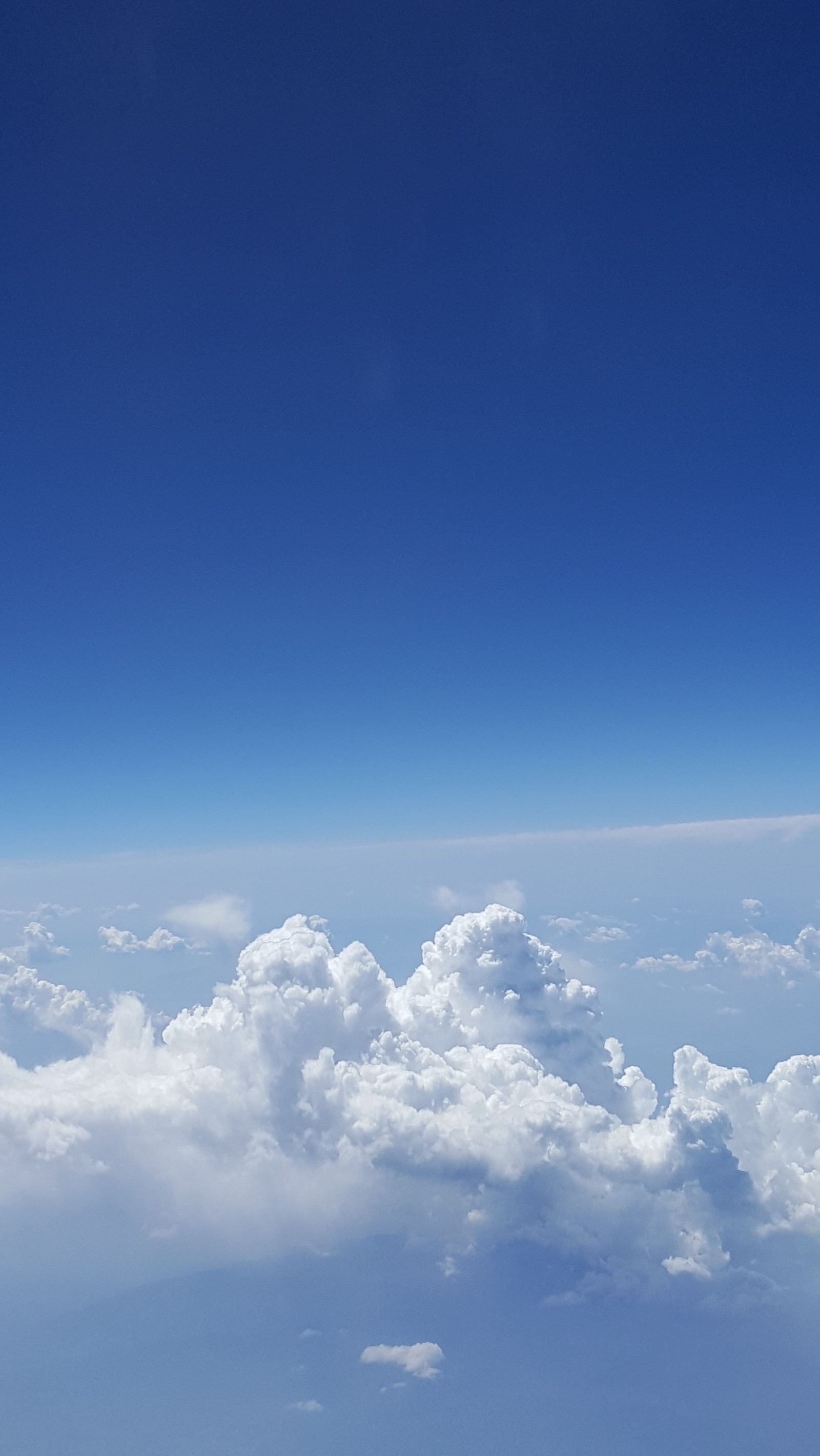 Um avião voando alto acima das nuvens no céu (azul, nuvens, terra, horizonte, céus)