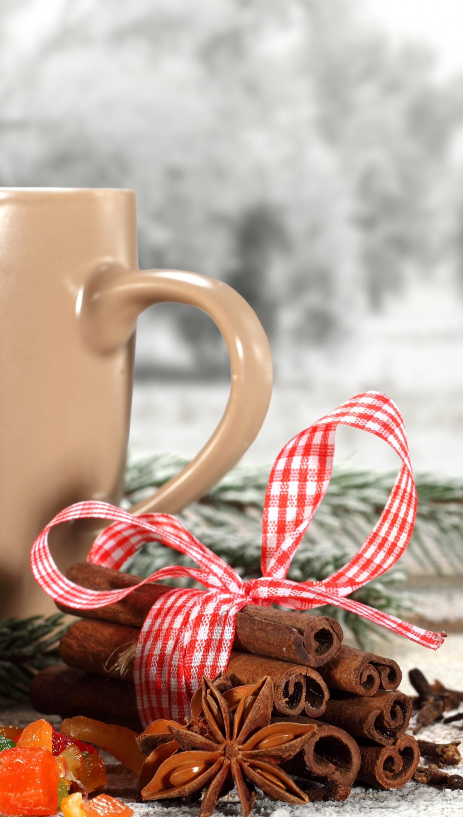 There is a cup of coffee and cinnamons on a table (christmas, cinnamon, tea)