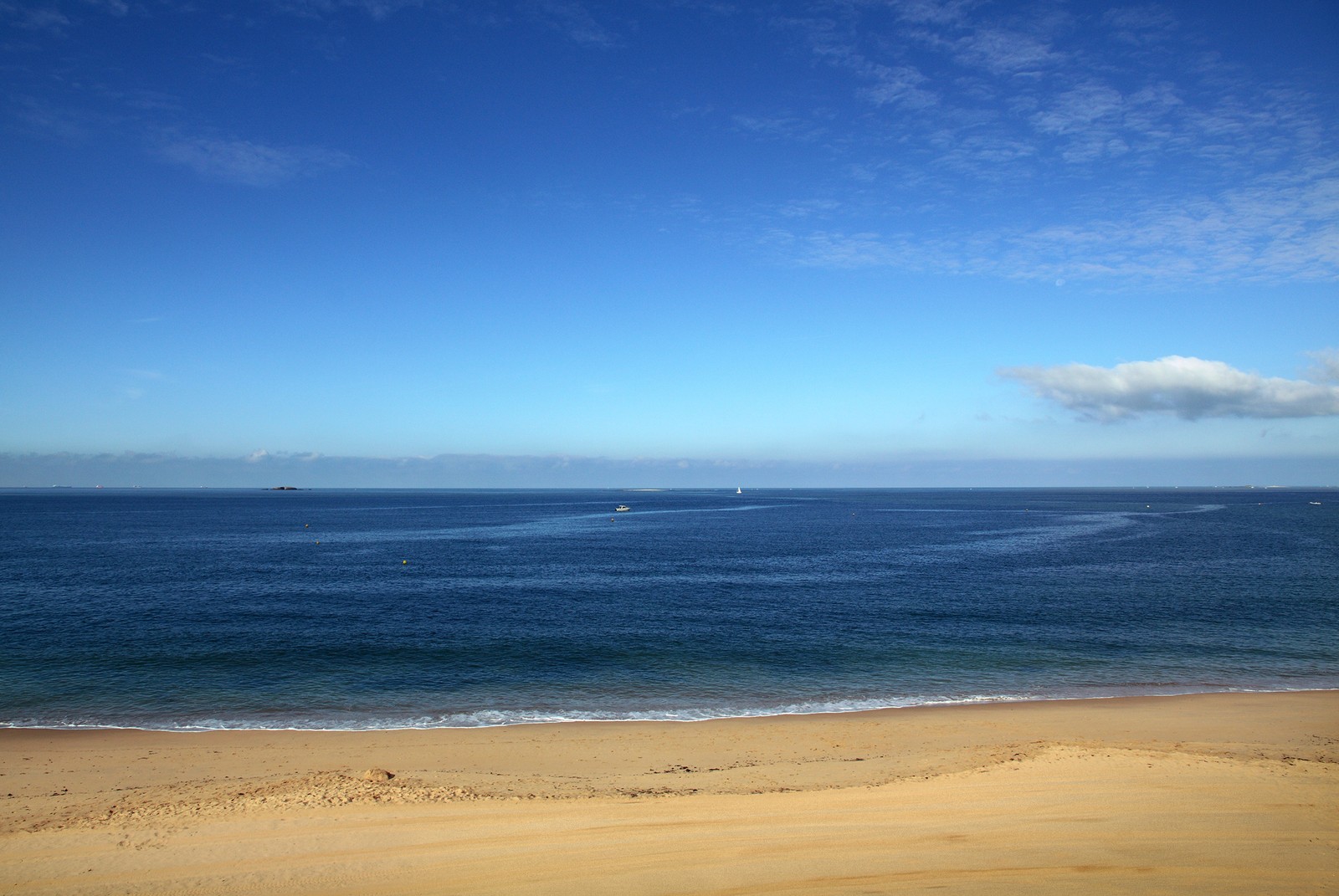 There is a boat out on the water in the ocean (coast, landscape, nature)