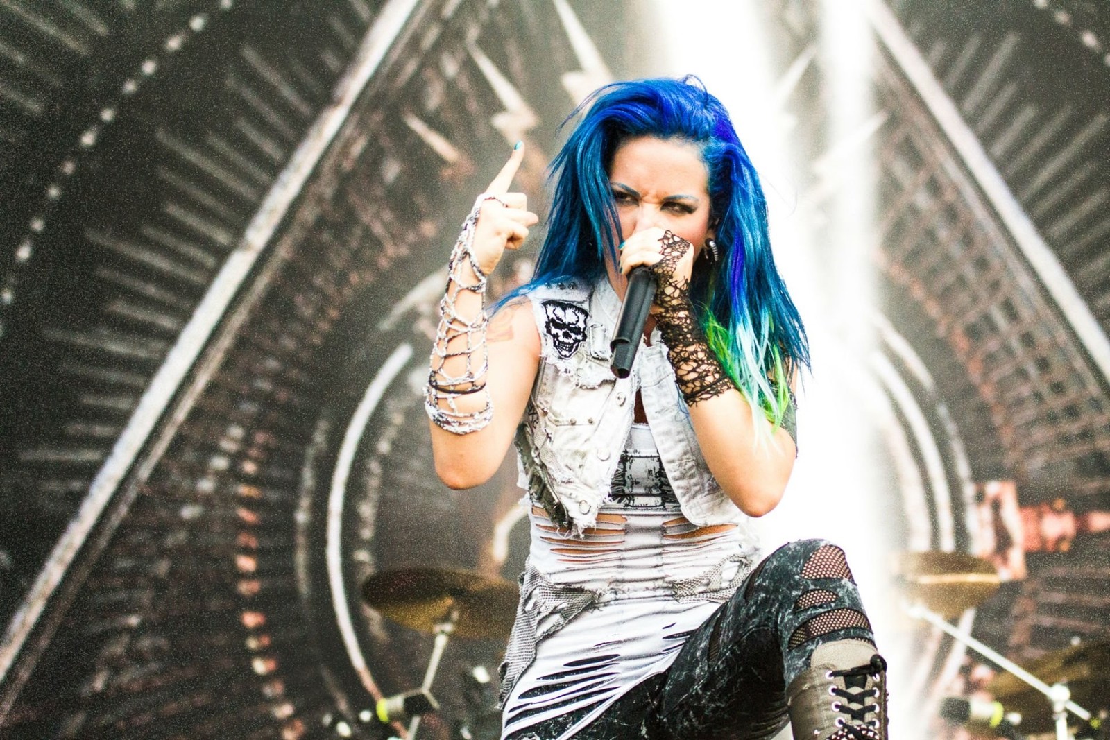 Arafed woman with blue hair and piercings on stage (music artist, performance, music, productivity, girl)