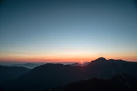 Impresionante amanecer sobre el horizonte montañoso con vibrante resplandor