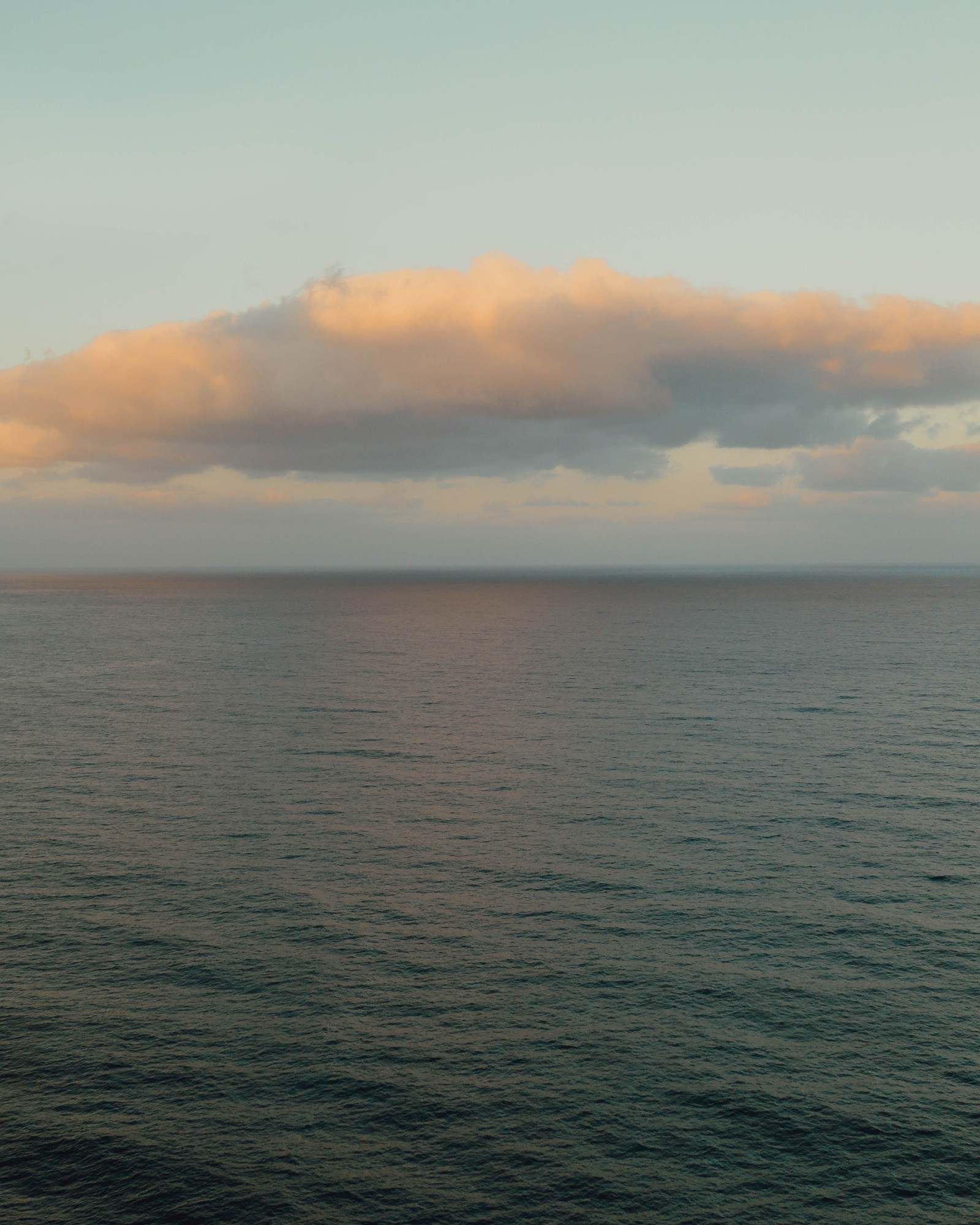 Il y a un bateau sur l'eau au milieu de l'océan (promontoire, calme, mer, horizon, son)