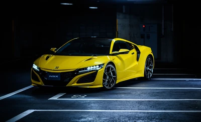 Honda NSX en jaune vif, illuminé dans un parking faiblement éclairé.