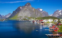 Malerisches Fischerdorf Lofoten, umgeben von majestätischen Bergen und ruhigen Fjordreflexionen.