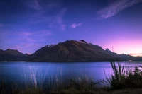 Majestuoso atardecer sobre el lago Wakatipu con cielo estrellado y reflejos de montañas