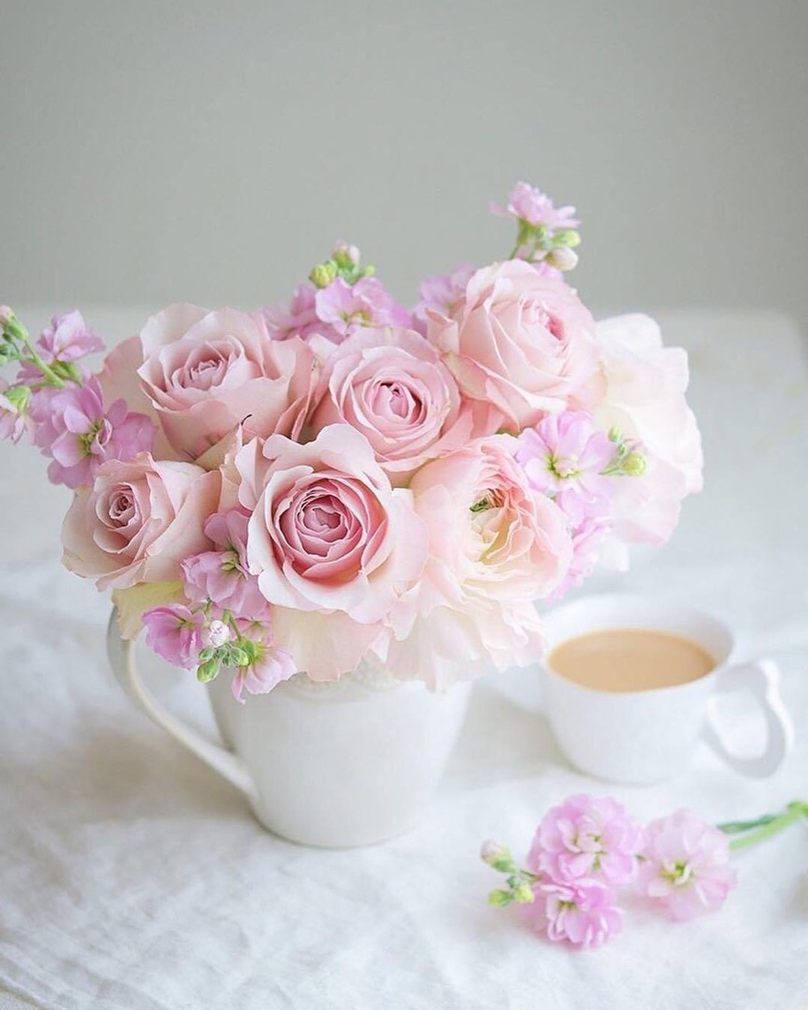 Une tasse blanche avec des fleurs roses dedans et une tasse de café à côté (matin, rose, fleur, blanc, roses de jardin)