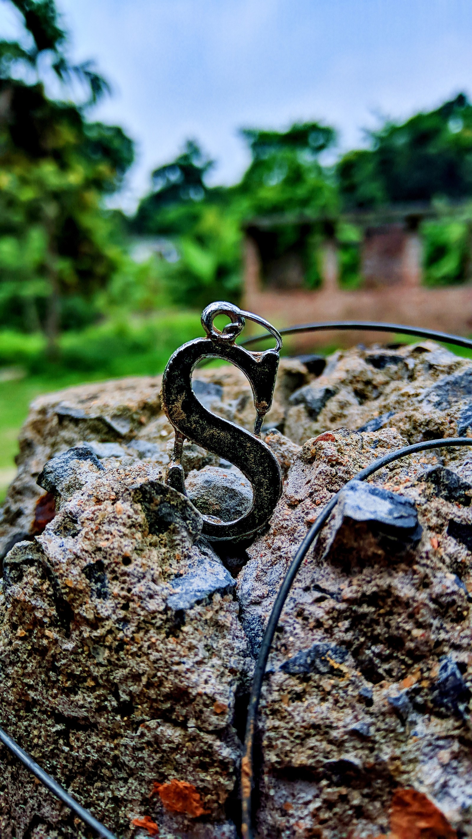 Ein metallisches objekt auf einem stein inmitten eines parks (design, fotografie, symbol)