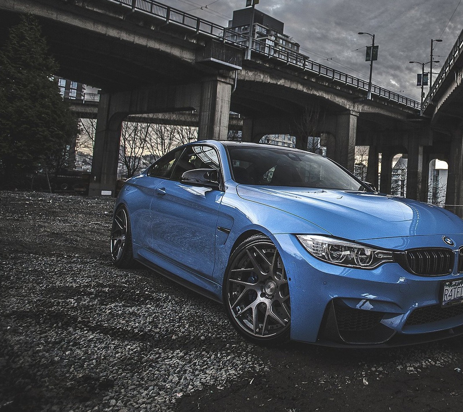 Un gros plan d'une voiture bmw bleue garée devant un pont (bmw, voiture, design, nouveau)