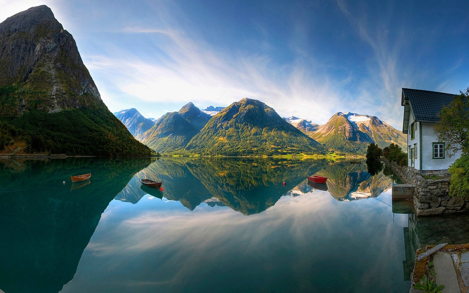 Una casa de vacaciones en un lago con montañas al fondo (noruega, fiordo, montaña, reflexión, naturaleza)