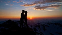 Amour en silhouette au lever du soleil au sommet de la montagne