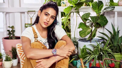 Sara Ali Khan dans une pose décontractée entourée de verdure luxuriante et de plantes vibrantes.