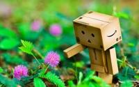 Robô Danbo explorando uma flor vibrante na natureza