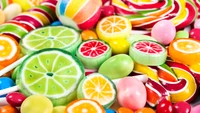 Colorful assortment of citrus-themed candies, including lime and key lime lollipops, surrounded by vibrant sweets and treats.