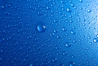 Gros plan de gouttes d'eau sur une surface bleue